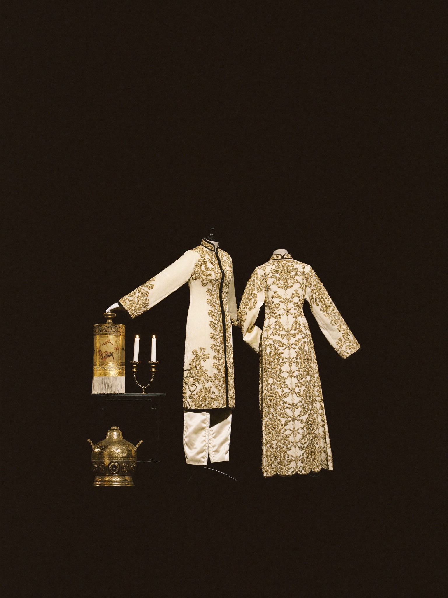 Costumes de scène brodés d’or dans une lumière théâtrale