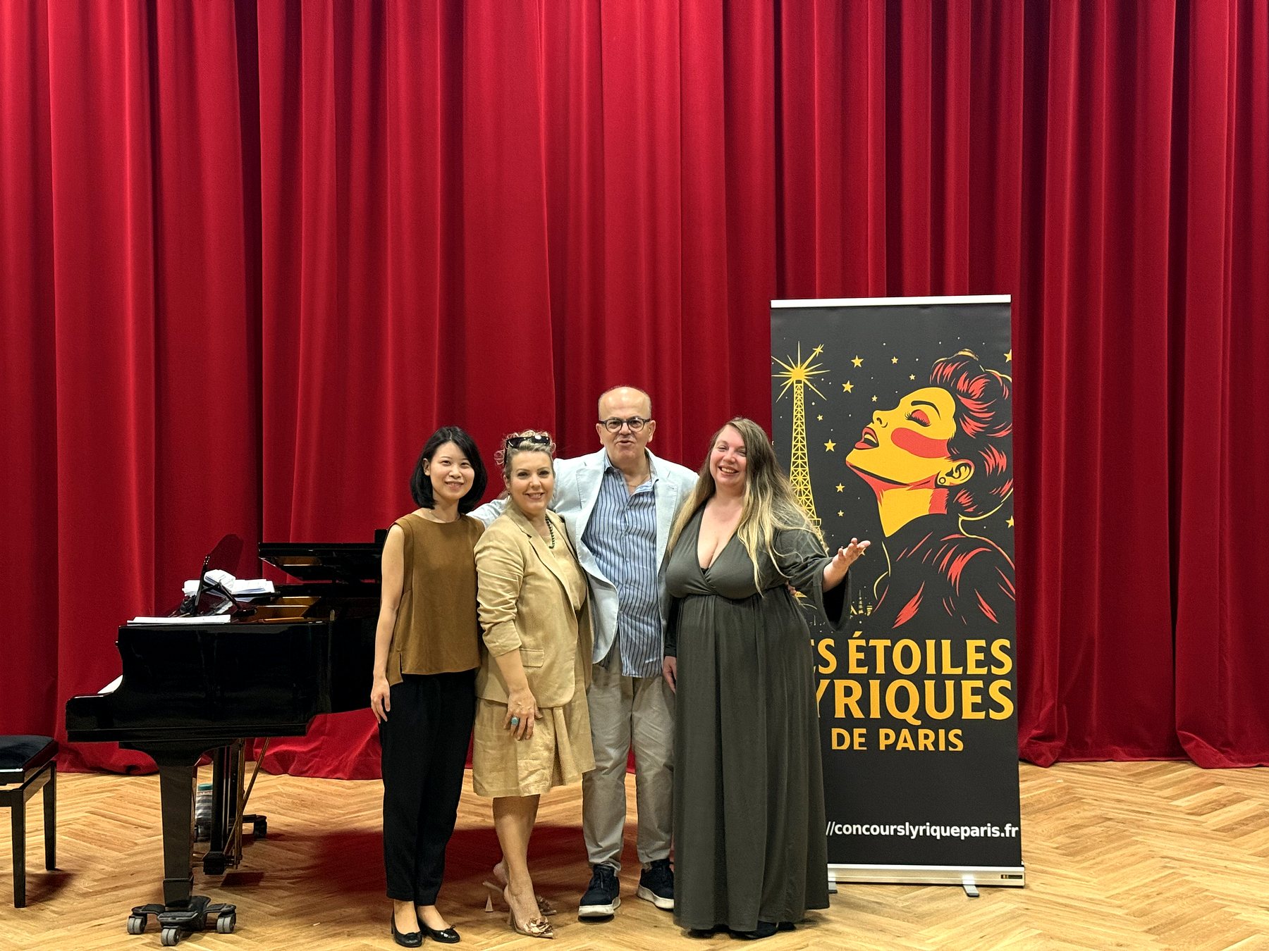L’équipe du concours devant l’affiche des Étoiles Lyriques de Paris