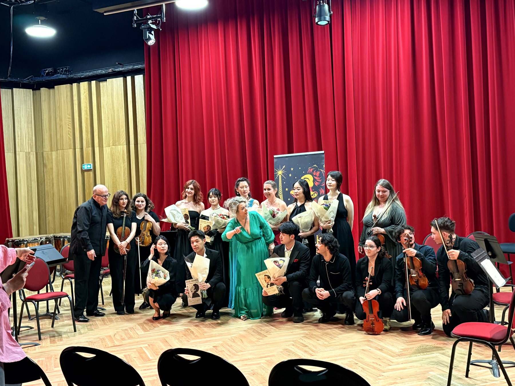 Les lauréats et les musiciens de l’orchestre sur scène, devant le rideau rouge